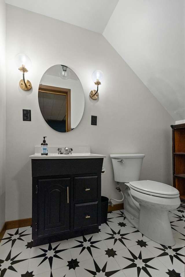 bathroom featuring vanity, toilet, tile patterned floors, and vaulted ceiling