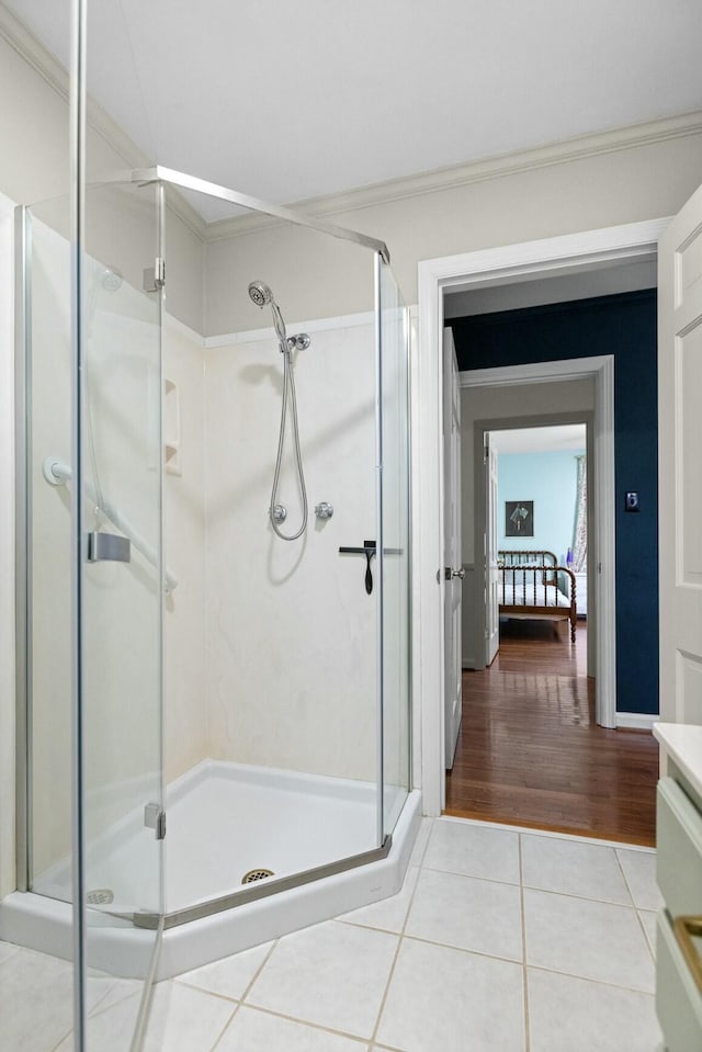 bathroom with vanity, a shower with shower door, tile patterned floors, and ornamental molding