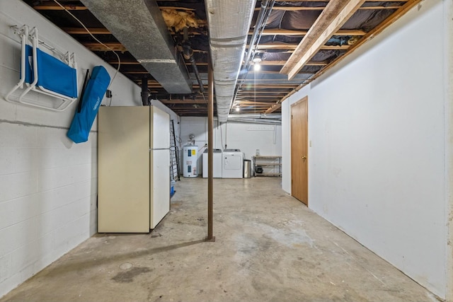 basement with water heater, white refrigerator, and washing machine and dryer