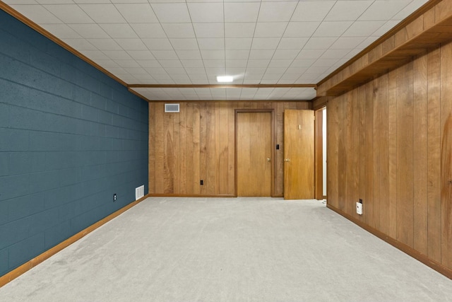 basement with wood walls and light colored carpet