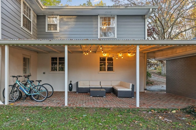 back of house with an outdoor living space and a patio