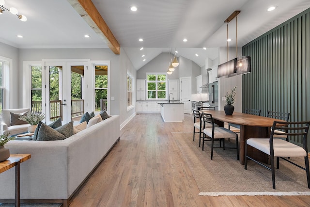 living room with french doors, vaulted ceiling with beams, and light hardwood / wood-style floors