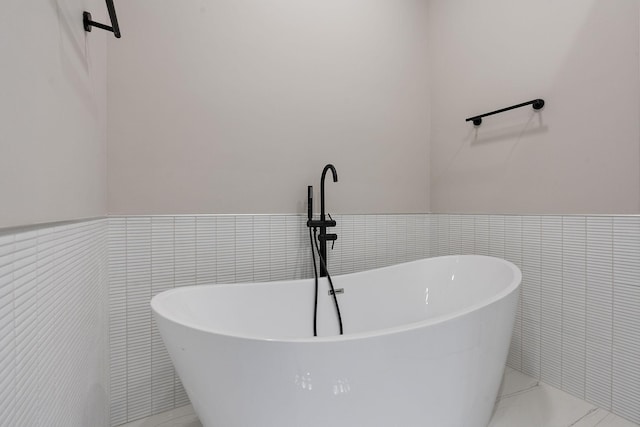 bathroom featuring tile walls and a bathtub