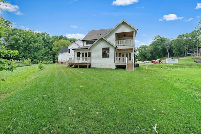 back of house featuring a balcony and a lawn