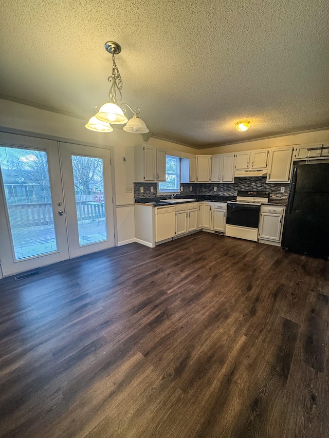 kitchen with dark wood finished floors, dark countertops, electric range, and freestanding refrigerator