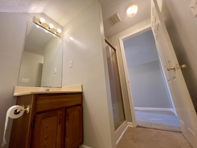 bathroom with vanity, visible vents, a stall shower, tile patterned flooring, and a textured ceiling