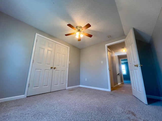 unfurnished bedroom with a closet, carpet flooring, a textured ceiling, and baseboards