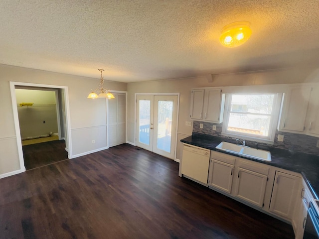 kitchen with dark wood-style floors, plenty of natural light, white dishwasher, a sink, and french doors