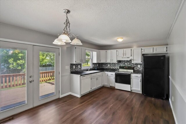kitchen with tasteful backsplash, visible vents, white dishwasher, range with electric stovetop, and freestanding refrigerator