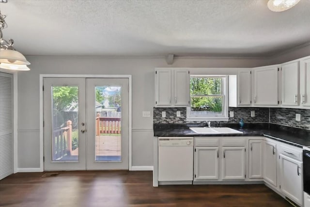 kitchen featuring white dishwasher, french doors, a sink, and dark countertops