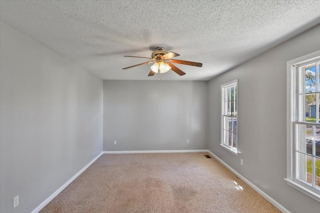 empty room featuring a textured ceiling, baseboards, a ceiling fan, and carpet floors