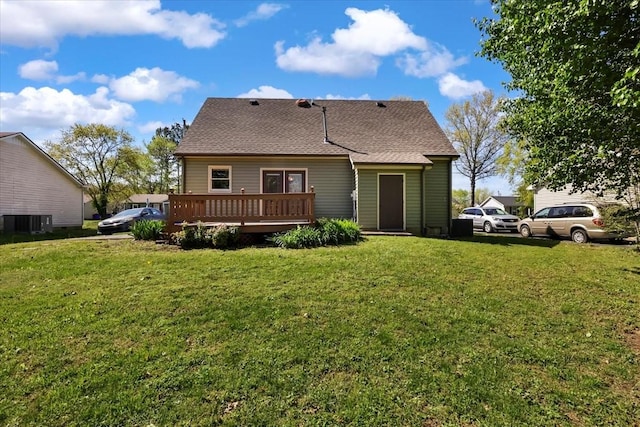 rear view of house featuring central air condition unit, a shingled roof, a yard, and a wooden deck