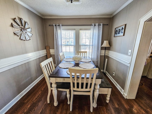 dining room featuring wood walls, crown molding, dark hardwood / wood-style floors, and a textured ceiling