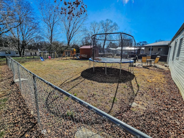 view of yard with a playground and a trampoline