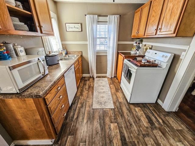 kitchen with sink, white appliances, dark wood-type flooring, and washer / clothes dryer