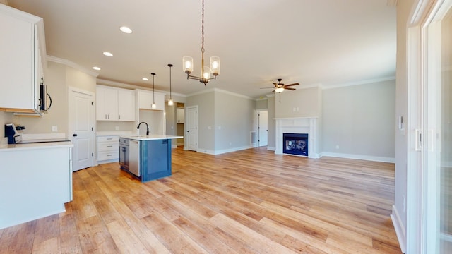 kitchen featuring appliances with stainless steel finishes, decorative light fixtures, white cabinetry, blue cabinets, and an island with sink