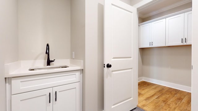 bathroom featuring wood-type flooring, vanity, and crown molding