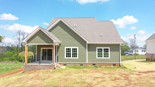 rear view of house with covered porch and a yard