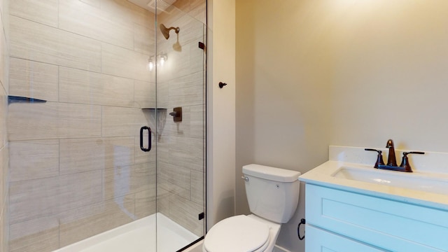 bathroom with toilet, vanity, and an enclosed shower