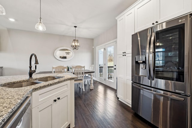 kitchen with hanging light fixtures, white cabinetry, appliances with stainless steel finishes, and sink