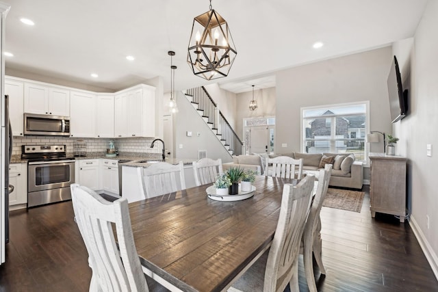 dining room featuring dark wood-type flooring, sink, and a notable chandelier