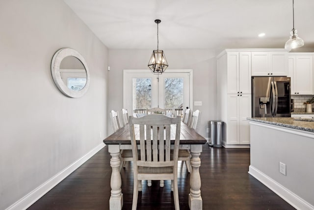 dining room with dark hardwood / wood-style flooring and an inviting chandelier