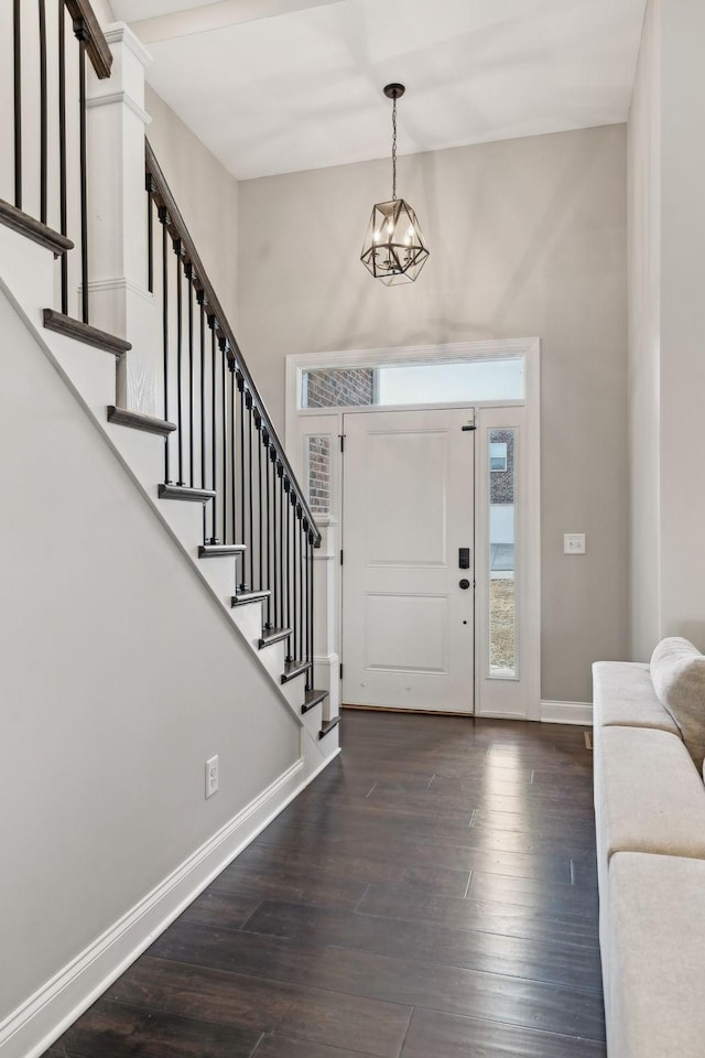 foyer entrance featuring a notable chandelier and dark wood-type flooring