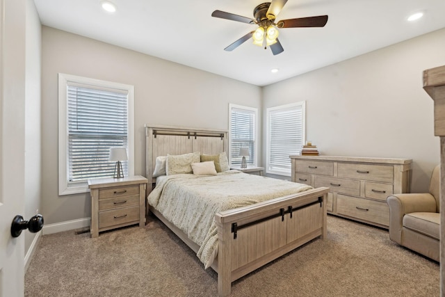 carpeted bedroom featuring multiple windows and ceiling fan