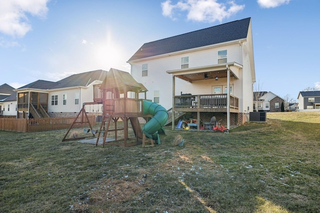 back of property with central AC unit, a yard, and a playground