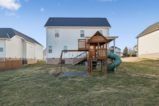 back of house with a lawn and a playground