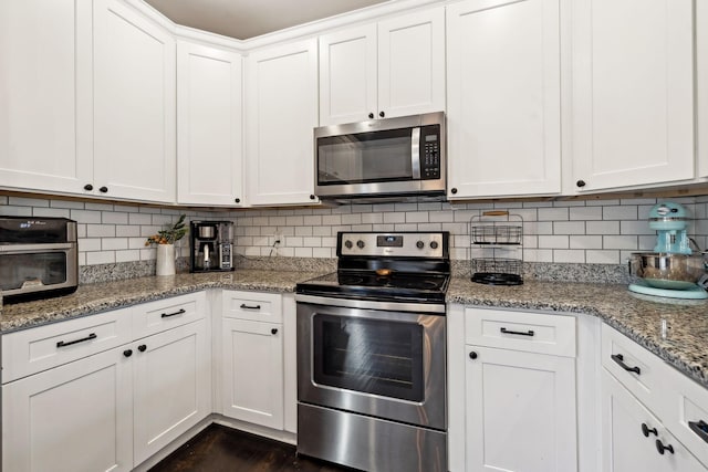 kitchen with white cabinetry, backsplash, light stone countertops, and appliances with stainless steel finishes