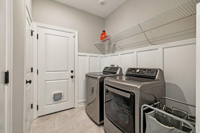 clothes washing area featuring light tile patterned flooring and independent washer and dryer