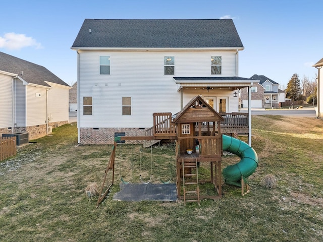 rear view of house featuring a yard and a playground