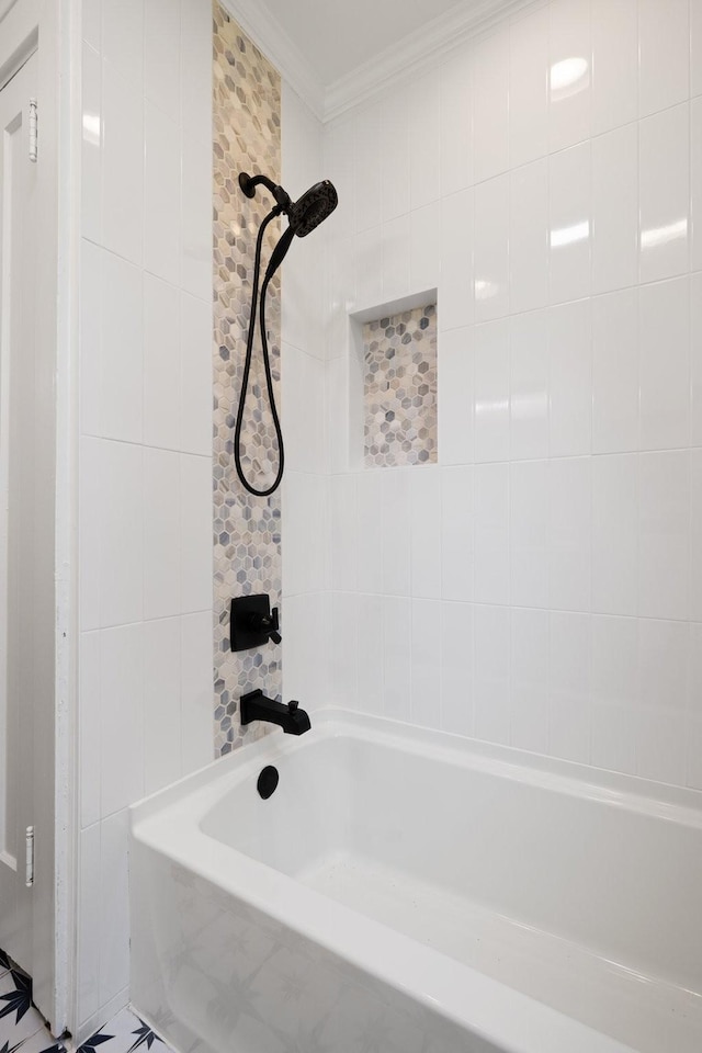 bathroom with ornamental molding and tiled shower / bath combo