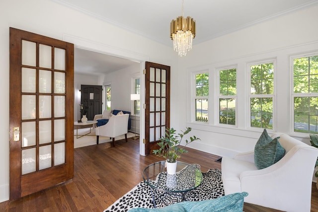 interior space with ornamental molding, an inviting chandelier, and dark hardwood / wood-style flooring