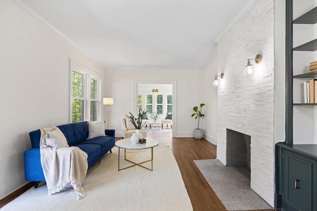 living room with dark hardwood / wood-style floors, crown molding, and a fireplace