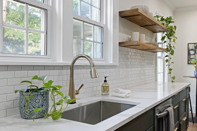 kitchen with sink, light stone counters, and plenty of natural light