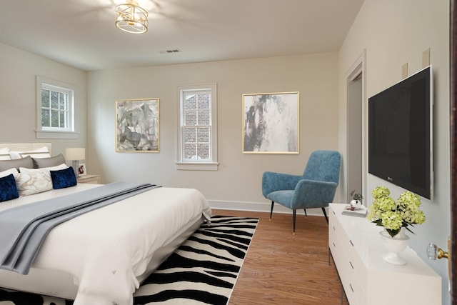 bedroom with light wood-type flooring and multiple windows