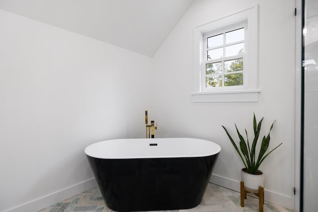 bathroom featuring a bathtub and vaulted ceiling