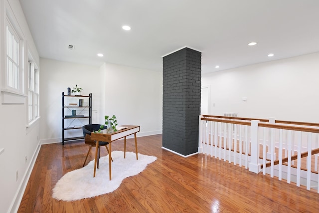 office space with decorative columns and dark hardwood / wood-style floors