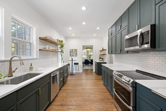 kitchen with sink, light hardwood / wood-style flooring, a wealth of natural light, and stainless steel appliances