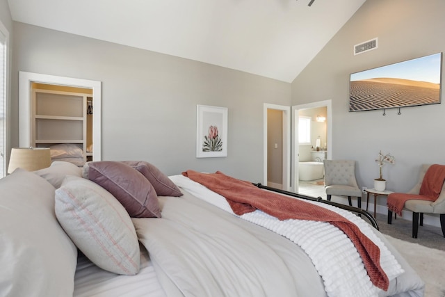 carpeted bedroom with connected bathroom and lofted ceiling