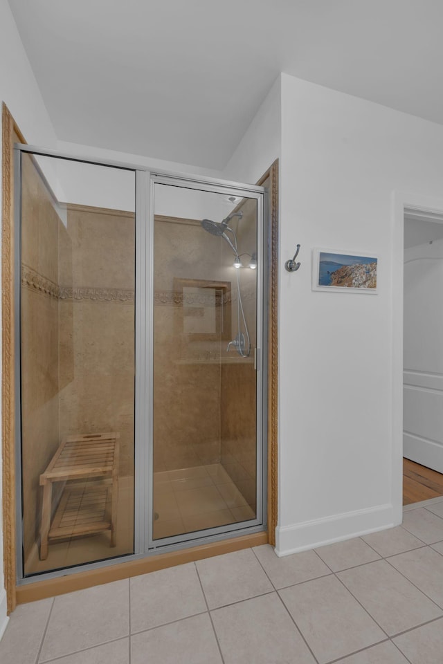 bathroom with a shower with door and tile patterned flooring