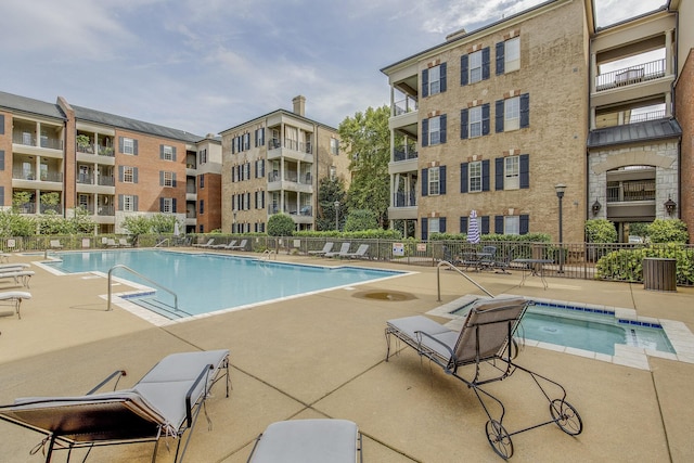 view of swimming pool with a hot tub and a patio