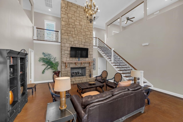 living room with ceiling fan with notable chandelier, a high ceiling, ornamental molding, and a stone fireplace