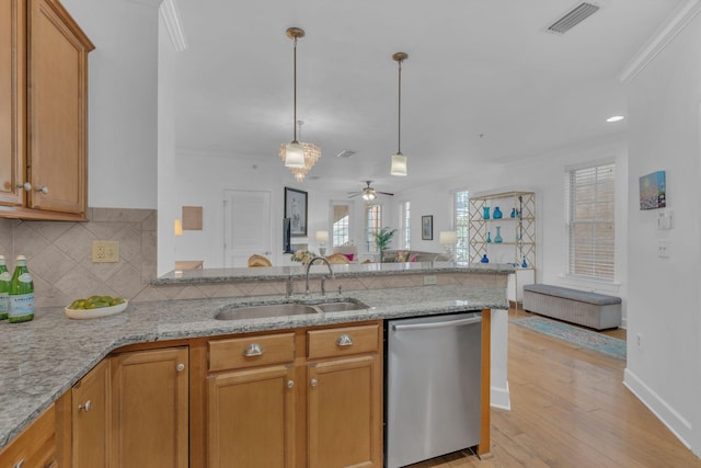 kitchen featuring kitchen peninsula, crown molding, stainless steel dishwasher, sink, and light stone counters