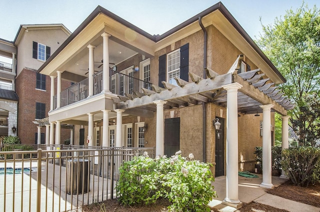 exterior space featuring a fenced in pool, a balcony, ceiling fan, and a pergola