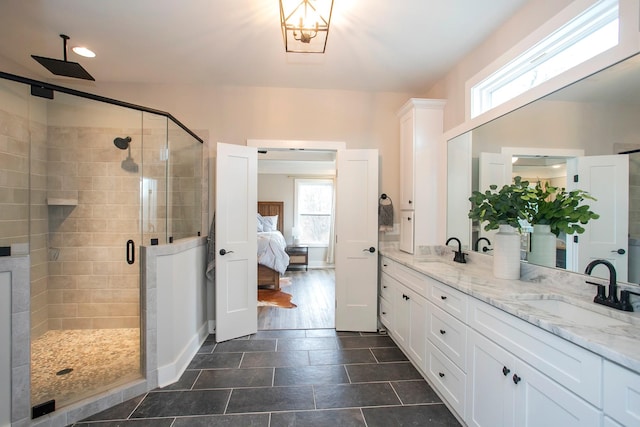 bathroom featuring a shower with shower door and vanity