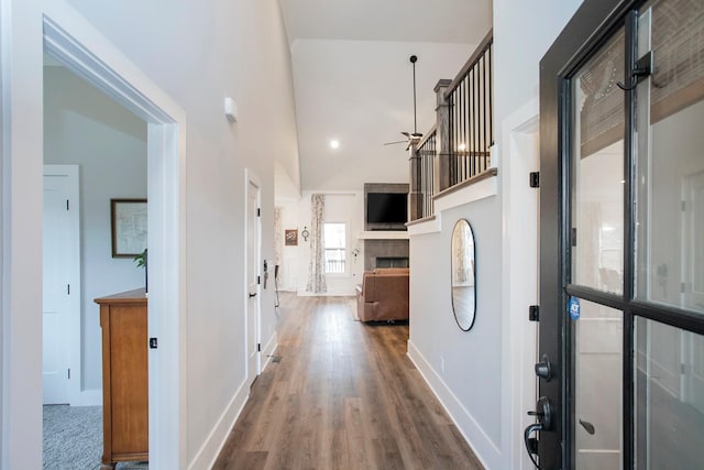 hall featuring hardwood / wood-style flooring and high vaulted ceiling