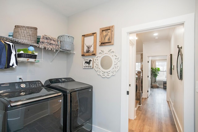 washroom with washer and clothes dryer and light wood-type flooring